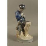 A Royal Copenhagen figure of a young boy seated whittling a stick, no.