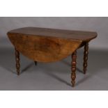 A 19th century French oak circular drop leaf dining table, on turned legs,