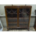 A mahogany bookcase having two tracery glazed doors the interior fitted with shelves and on short