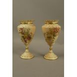 A pair of Royal Worcester vases the urnular bodies decorated with flowers and grasses on an apricot