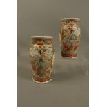 A pair of Japanese satsuma vases decorated with figures in landscapes within formal borders,