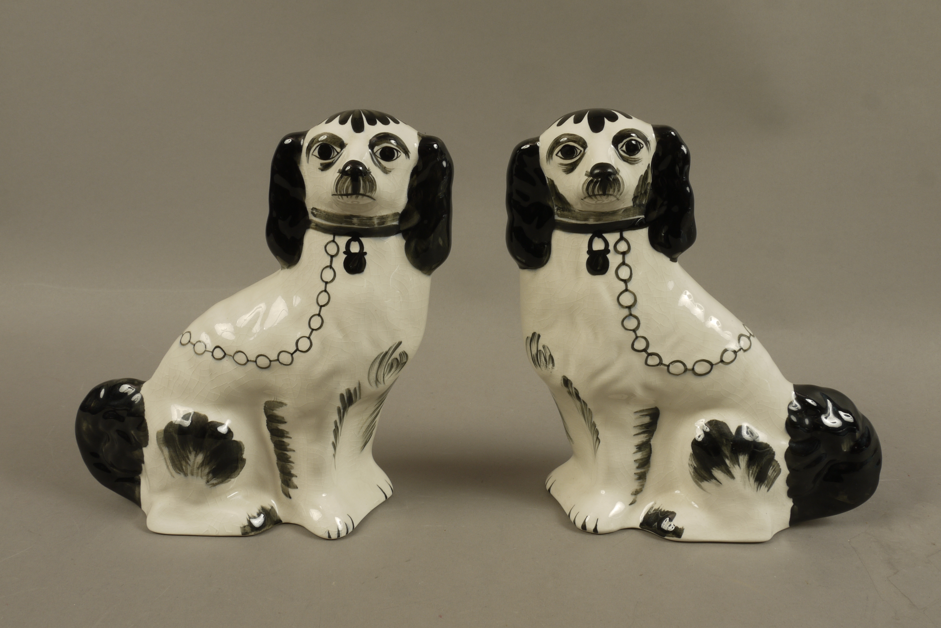 A pair of reproduction pottery Staffordshire spaniels,