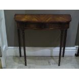 A mahogany finished hall table of serpentine outline with two drawers,