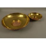 Two graduated brass and copper circular bowls,