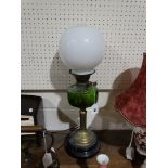 A Circular Based Brass Column Oil Lamp With Green Glass Reservoir