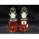 A Pair Of Cranberry Tinted And Etched Perfume Bottles And Stoppers