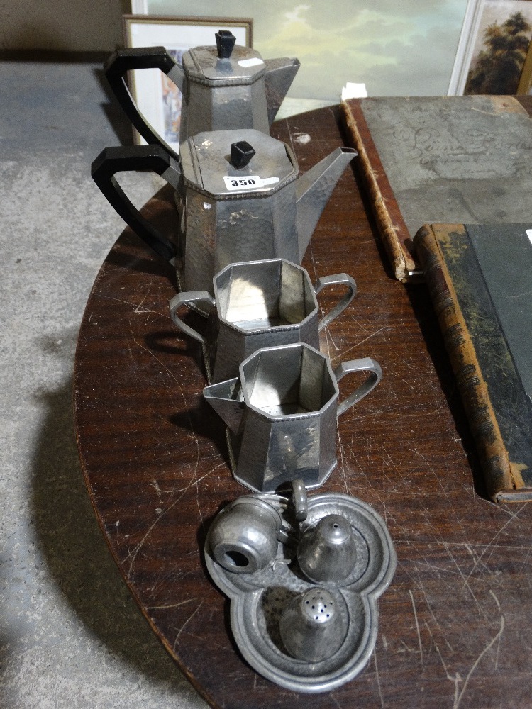 A Four Piece Beaten Pewter Tea Service Together With A Condiment Set