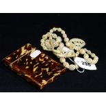 A Carved Bone Bead Necklace Together With A 19th Century Tortoise Shell Covered Card Case