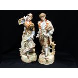 A Pair Of Edwardian Coloured Bisque China Figures In Fine Dress, 16" High