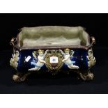 A Blue Ground Relief Moulded German Majolica 4 Footed Planter Decorated With Cherubs & Acanthus