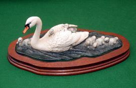 CERAMICS: Border Fine Arts hand painted ceramic of swan with cygnets, mounted on polished mahogany