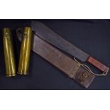 A WWII period British machete with scabbard and a pair of 1942 Royal Artillery shell cases. The