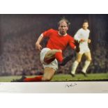 Bobby Charlton Signed Football Print a colour print depicting Charlton in an action scene, limited