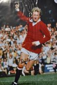 Denis Law Signed Manchester United Colour football Print depicting Law celebrating signed in ink,