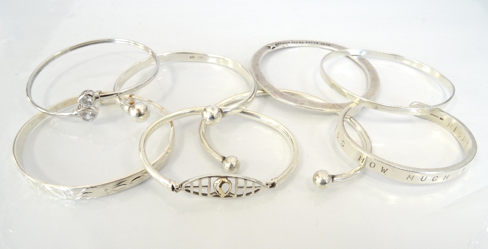 EIGHT SILVER BANGLES of various size and design (8)