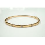 DIAMOND SET EIGHTEEN CARAT GOLD BANGLE the three diamonds totalling 0.