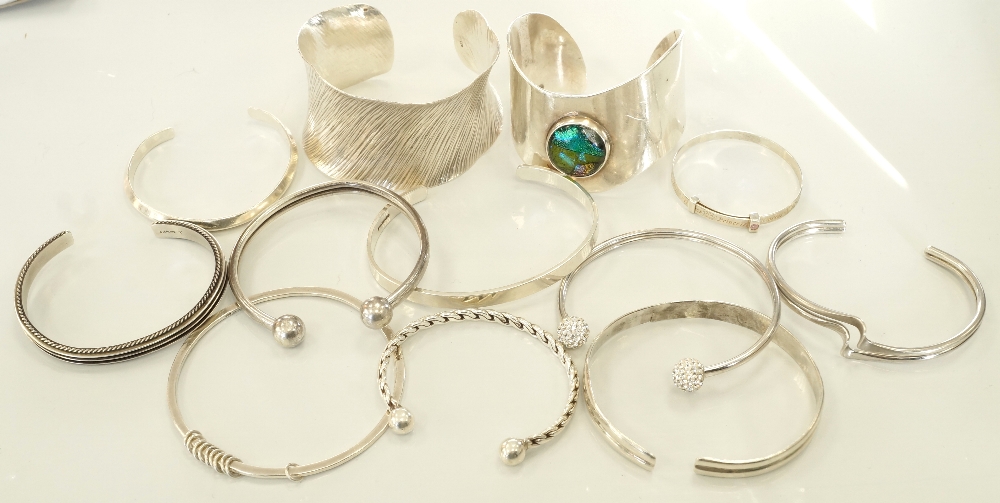 TWELVE SILVER BANGLES AND CUFFS of various designs,