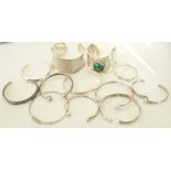 TWELVE SILVER BANGLES AND CUFFS of various designs,