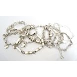 NINE SILVER BRACELETS of various designs, including one with elephant links,