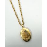 NINE CARAT GOLD LOCKET PENDANT with engraved bird and floral decoration,