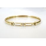 DIAMOND SET NINE CARAT GOLD BANGLE the diamond in pierced surround, approximately 6.