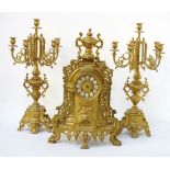 GILT BRASS CLOCK GARNITURE with an eight day movement striking on a bell,