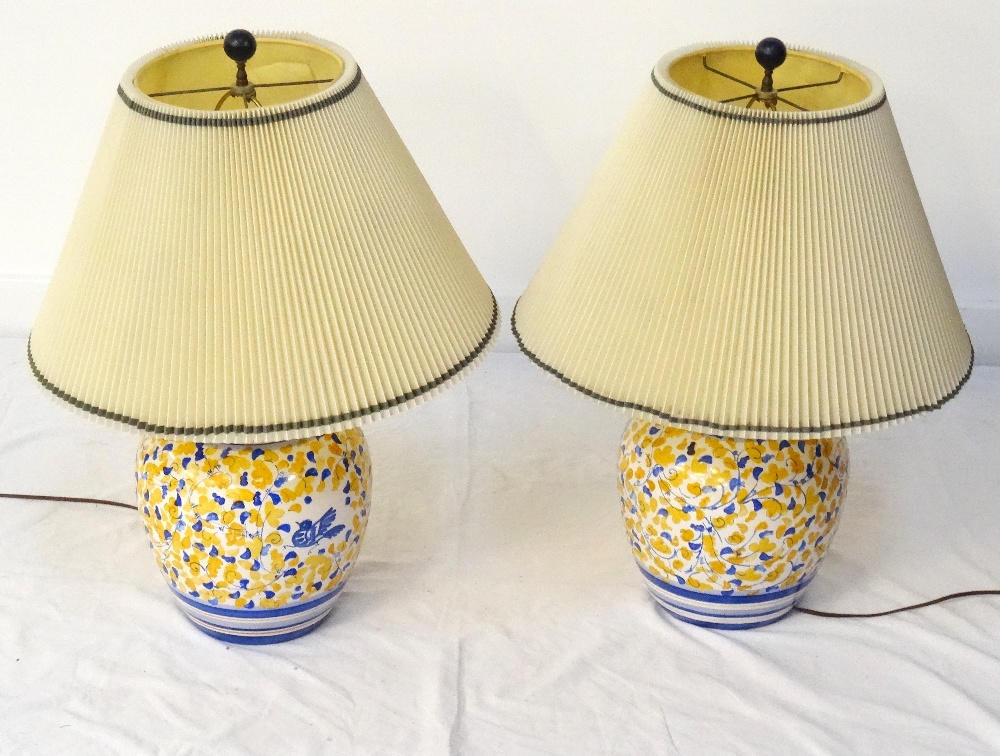 PAIR OF POTTERY TABLE LAMPS with bulbous bodies decorated with birds and foliage,