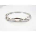 NINE CARAT WHITE GOLD TWIST DESIGN BANGLE with safety clasp, approximately 9.