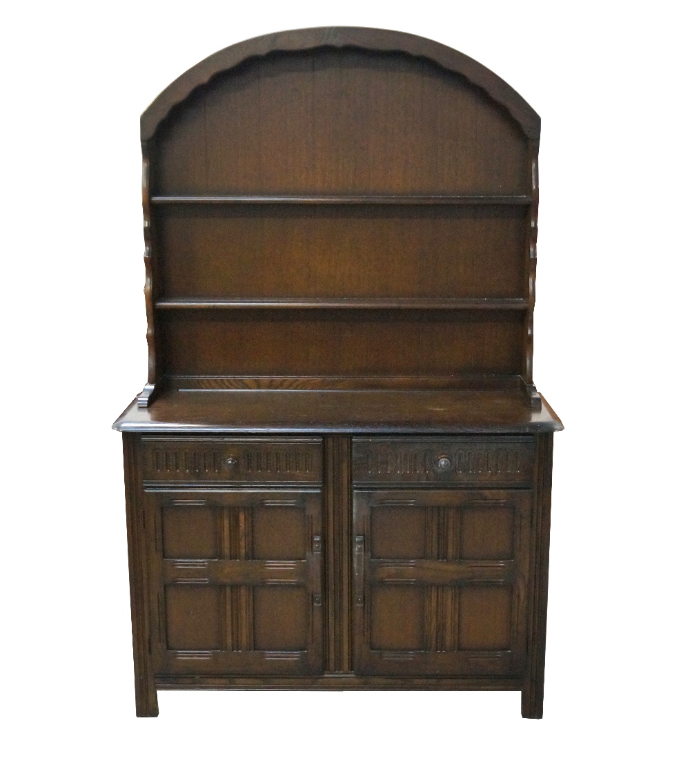 DARK OAK DRESSER the arched upper section with a scalloped border and two shelves,