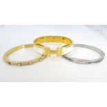 TWO CZ SET MICHAEL KORS BRACELETS one in yellow gold tone and the other silver tone;