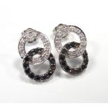 PAIR OF BLACK AND WHITE DIAMOND EARRINGS of entwined circle design, in nine carat white gold,