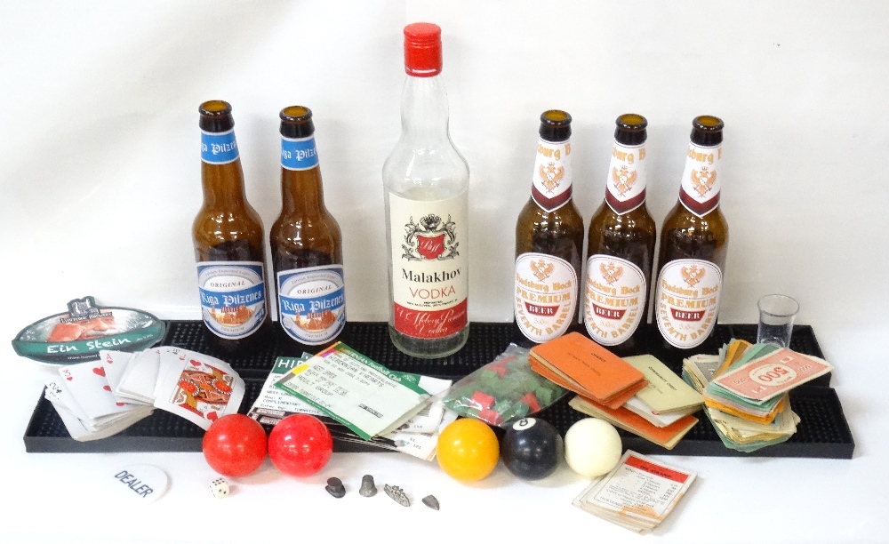 COLLECTION OF EMPTY BEER AND VODKA BOTTLES alongside a shot glass,