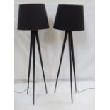 PAIR OF BLACK METAL FLOOR LAMPS each with three shaped supports,