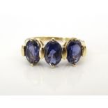 IOLITE THREE STONE RING on nine carat gold shank,