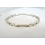 DIAMOND SET NINE CARAT WHITE GOLD BANGLE the hinged bangle with five flush set diamonds,