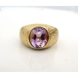 AMETHYST DRESS RING the oval cut amethyst on nine carat gold shank with textured shoulders,