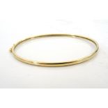 NINE CARAT GOLD BANGLE with safety clasp, approximately 3.