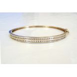 CZ SET NINE CARAT GOLD BANGLE with safety clasp, approximately 9.