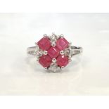 RUBY AND CZ CLUSTER RING on nine carat white gold shank with decorative split shoulders,