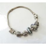 PANDORA MOMENTS SILVER CHARM BRACELET with four charms and two clips,