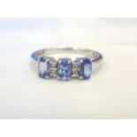 TANZANITE AND DIAMOND RING the three oval cut tanzanites separated by smaller diamonds,