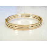 THREE TONE NINE CARAT GOLD BANGLE with safety clasp, approximately 10.