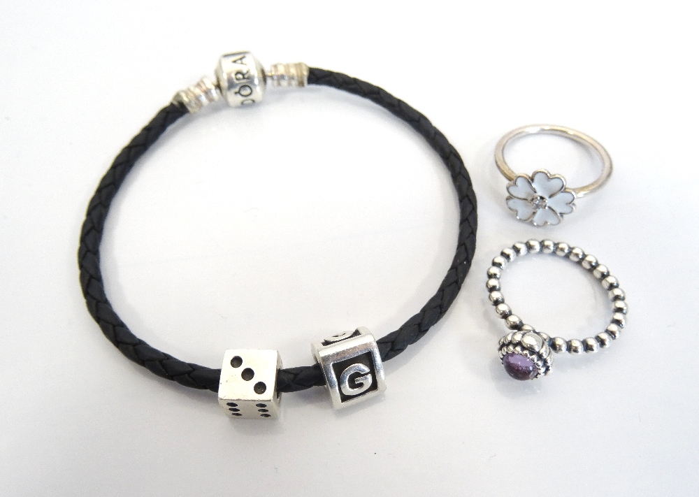 PANDORA BLACK BRAIDED BRACELET with two charms; together with two Pandora silver rings,