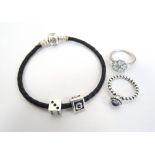 PANDORA BLACK BRAIDED BRACELET with two charms; together with two Pandora silver rings,