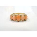 GRADUATED CORAL FIVE STONE RING on nine carat gold shank,