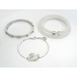 THREE SWAROVSKI CRYSTAL BRACELETS comprising a white Crystaldust double bangle, a hinged bangle,