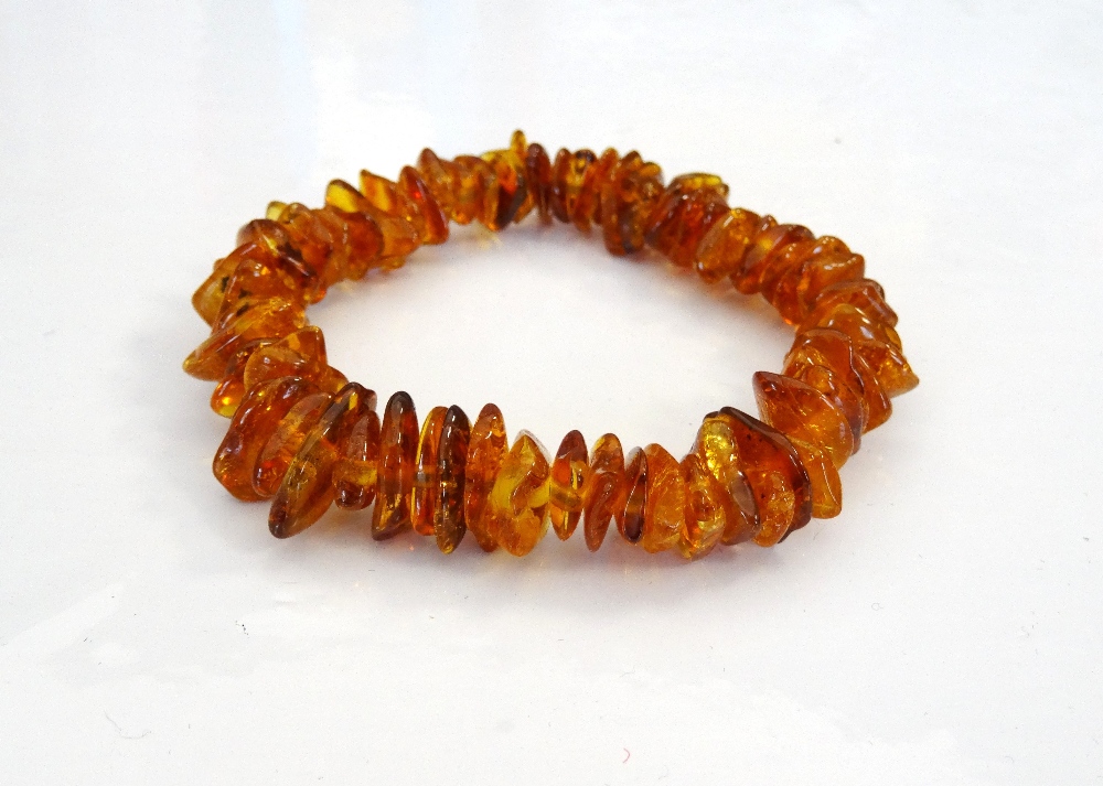 'COPPERSON' AMBER BEAD BRACELET formed with irregular amber beads on elasticated band,