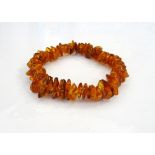 'COPPERSON' AMBER BEAD BRACELET formed with irregular amber beads on elasticated band,