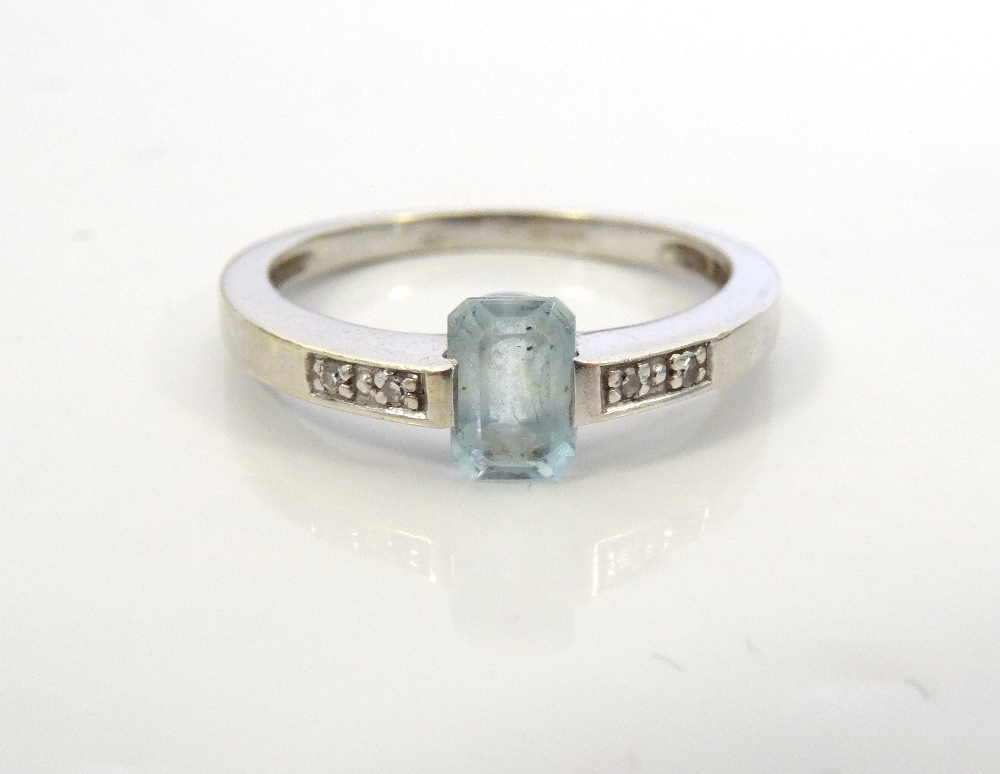 AQUAMARINE AND DIAMOND RING the central step cut aquamarine flanked by diamond set shoulders,