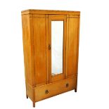 OAK WARDROBE with a moulded top above a central mirrored door flanked by panels with carved detail,